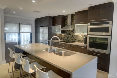 Contemporary single-wall kitchen in Miami with a double-bowl sink, flat-panel cabinets, dark wood cabinets, quartzite benchtops, glass sheet splashback, stainless steel appliances, porcelain floors and with island.