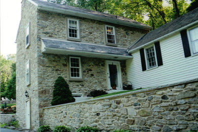 Design ideas for an expansive country two-storey beige exterior in Philadelphia with stone veneer.