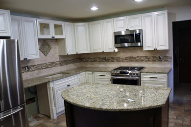 Enclosed kitchen - mid-sized craftsman u-shaped travertine floor enclosed kitchen idea in Boise with a double-bowl sink, raised-panel cabinets, white cabinets, granite countertops, beige backsplash, ceramic backsplash, stainless steel appliances and an island