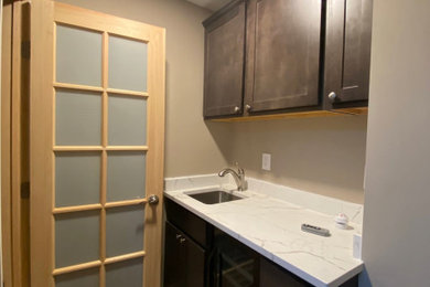Wet bar - mid-sized contemporary wet bar idea in Other with an undermount sink, shaker cabinets, brown cabinets, quartz countertops and quartz backsplash