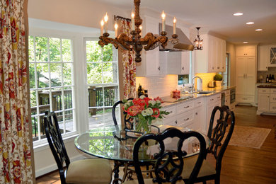 Example of a trendy dark wood floor kitchen design in Atlanta with shaker cabinets, white cabinets, granite countertops, white backsplash, subway tile backsplash and an island