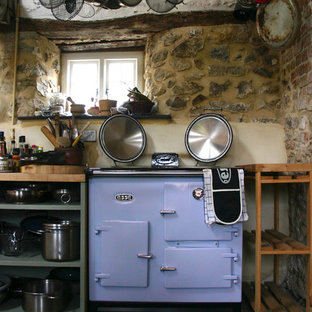 Farmhouse kitchen pantry photos - Example of a country slate floor kitchen pantry design in Essex with wood countertops and no island