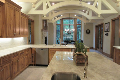 Inspiration for a large transitional limestone floor and gray floor kitchen remodel in Dallas with an undermount sink, beaded inset cabinets, medium tone wood cabinets, quartzite countertops, beige backsplash, porcelain backsplash, stainless steel appliances, an island and beige countertops