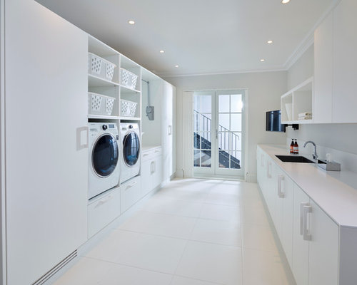 Modern Laundry Room London Modern galley utility room idea in London with a single-bowl sink, white walls