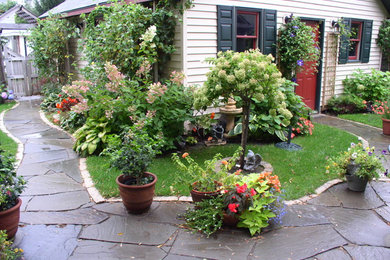 Photo of a mid-sized contemporary partial sun backyard stone landscaping in Minneapolis for summer.