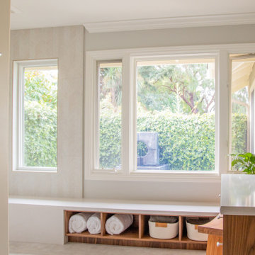 Natural light is abundant through large windows into a private enclosed garden.
