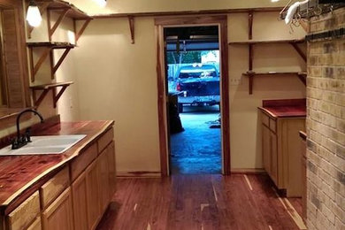 Example of a mid-sized galley medium tone wood floor eat-in kitchen design in Austin with a drop-in sink and no island