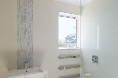 This is an example of a small contemporary bathroom in Perth with a wall-mount sink, beige tile, ceramic tile, beige walls and ceramic floors.