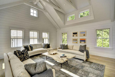 Inspiration for a mid-sized transitional enclosed light wood floor, vaulted ceiling and shiplap wall family room remodel in New York with white walls