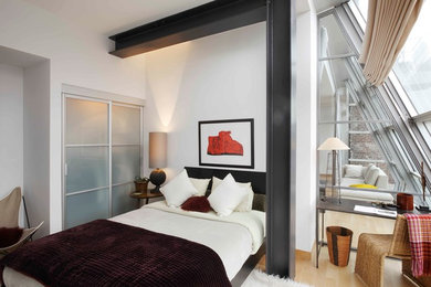 Example of a trendy light wood floor bedroom design in New York with white walls