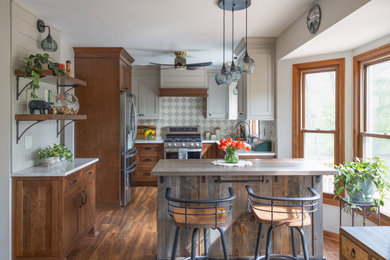 Inspiration for a small transitional u-shaped dark wood floor and brown floor eat-in kitchen remodel in Chicago with shaker cabinets, medium tone wood cabinets, stainless steel appliances, an island, multicolored backsplash and white countertops