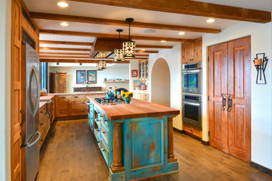 Large southwest l-shaped medium tone wood floor and brown floor open concept kitchen photo in Seattle with a farmhouse sink, recessed-panel cabinets, turquoise cabinets, wood countertops, multicolored backsplash, ceramic backsplash, stainless steel appliances and an island