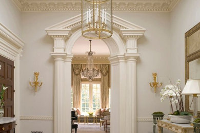 Example of a large classic ceramic tile and multicolored floor entryway design with white walls and a dark wood front door