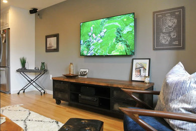 Example of a minimalist orange floor living room design in Boston with gray walls and a wall-mounted tv