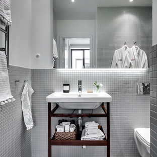 Inspiration för mellanstora nordiska badrum, med öppna hyllor, skåp i mörkt trä, en vägghängd toalettstol, grå väggar, mosaikgolv, ett väggmonterat handfat och mosaik