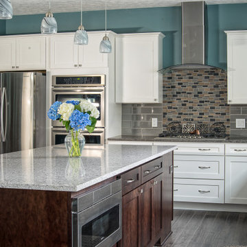 Transitional kitchen with reflective dark glass backsplash & glass fireplace.