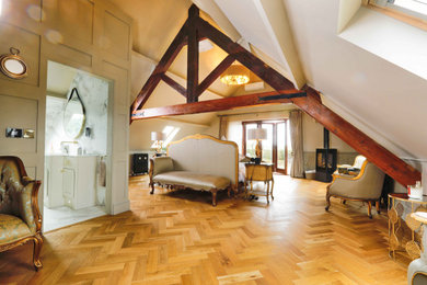 Foto de dormitorio principal campestre con paredes beige, suelo de madera en tonos medios, estufa de leña, suelo marrón y vigas vistas