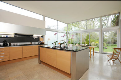 Photo of a mid-sized contemporary l-shaped eat-in kitchen in Edinburgh with a double-bowl sink, flat-panel cabinets, light wood cabinets, quartz benchtops, black splashback, stone slab splashback, stainless steel appliances, porcelain floors and with island.