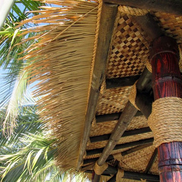 12'x12' Maldives inspired Hut in Synthetic thatch - carved poles in teak stain