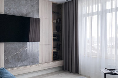 Ejemplo de salón con barra de bar gris y blanco actual de tamaño medio con paredes beige, suelo vinílico, televisor colgado en la pared, suelo beige y panelado