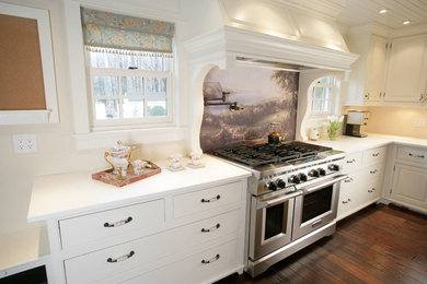 Inspiration for a mid-sized farmhouse l-shaped dark wood floor open concept kitchen remodel in New York with a farmhouse sink, raised-panel cabinets, white cabinets, solid surface countertops, stainless steel appliances and an island