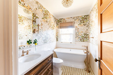 Example of a small classic white tile and ceramic tile ceramic tile, green floor, single-sink and wallpaper freestanding bathtub design in Denver with recessed-panel cabinets, medium tone wood cabinets, a two-piece toilet, an undermount sink, quartz countertops, white countertops and a freestanding vanity