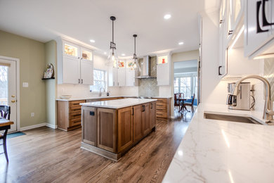 Large transitional l-shaped medium tone wood floor and brown floor eat-in kitchen photo in Baltimore with an undermount sink, shaker cabinets, medium tone wood cabinets, quartz countertops, white backsplash, porcelain backsplash, stainless steel appliances, an island and white countertops