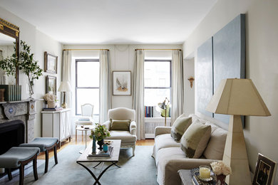Example of a classic formal living room design in New York with beige walls and a standard fireplace