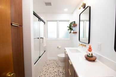 Photo of a mid-sized contemporary master bathroom in Other with flat-panel cabinets, dark wood cabinets, an alcove tub, an alcove shower, a two-piece toilet, white walls, porcelain floors, an undermount sink, engineered quartz benchtops, a sliding shower screen, white benchtops, a double vanity and a built-in vanity.