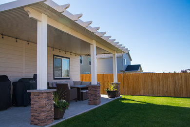 Example of a mid-sized trendy backyard patio design in Boise with an awning