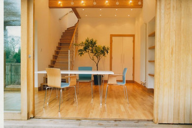 Пример оригинального дизайна: гостиная-столовая в современном стиле с светлым паркетным полом