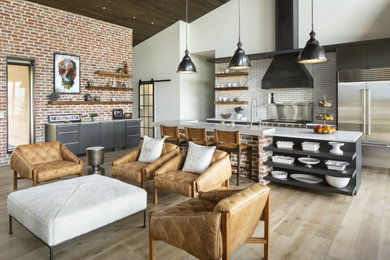 Urban light wood floor, brown floor and vaulted ceiling eat-in kitchen photo in Denver with flat-panel cabinets, gray cabinets, quartz countertops, white backsplash, ceramic backsplash, stainless steel appliances, an island and white countertops