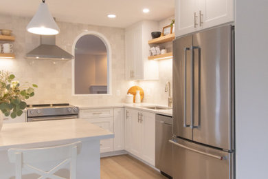 Inspiration for a mid-sized contemporary vinyl floor and brown floor open concept kitchen remodel in Vancouver with an undermount sink, shaker cabinets, white cabinets, quartzite countertops, gray backsplash, stainless steel appliances and an island