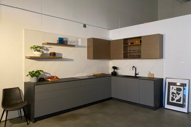 Small minimalist l-shaped concrete floor and gray floor eat-in kitchen photo in Vancouver with an undermount sink, flat-panel cabinets, gray cabinets, quartz countertops, white backsplash, quartz backsplash, no island and black countertops