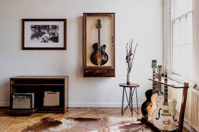 Diseño de salón con rincón musical retro con paredes blancas y suelo de madera clara