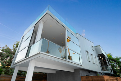 Modelo de fachada de casa bifamiliar blanca y gris actual pequeña de dos plantas con revestimiento de vidrio, tejado de un solo tendido y tejado de varios materiales