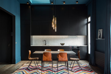 Design ideas for a mid-sized contemporary single-wall eat-in kitchen in Paris with beaded inset cabinets, black cabinets, marble benchtops, marble splashback, an undermount sink, white splashback, black appliances, medium hardwood floors, with island and brown floor.