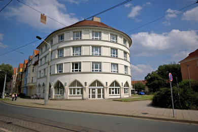 Großes, Dreistöckiges Klassisches Haus mit Putzfassade, weißer Fassadenfarbe, Mansardendach, Ziegeldach, braunem Dach und Dachgaube