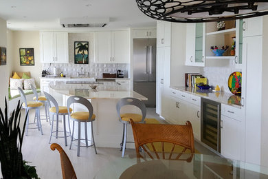 Inspiration for a contemporary eat-in kitchen remodel in Miami with an undermount sink, shaker cabinets, white cabinets, marble countertops, white backsplash, stainless steel appliances and an island