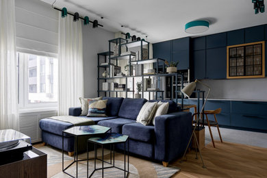 На фото: гостиная комната в белых тонах с отделкой деревом в современном стиле с бежевым полом и синим диваном