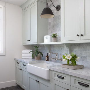 フェニックスの大きいカントリー風おしゃれな洗濯室 (エプロンフロントシンク、シェーカースタイル扉のキャビネット、緑のキャビネット、大理石カウンター、白い壁、レンガの床、左右配置の洗濯機・乾燥機、黒い床、グレーのキッチンカウンター) の写真