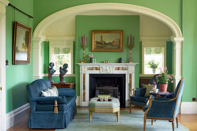 Eclectic living room in West Midlands with green walls, all types of fireplace and a stone fireplace surround.