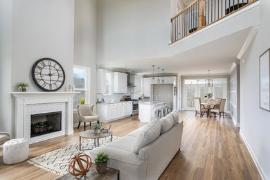 Mid-sized trendy formal and open concept medium tone wood floor and brown floor living room photo in Other with white walls, a standard fireplace, a brick fireplace and no tv