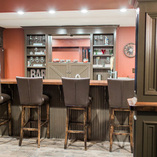 Photo of an expansive traditional fully buried basement in Boston with red walls, laminate floors, no fireplace and brown floors.