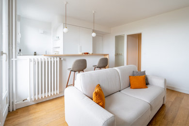 Modelo de salón abierto y blanco y madera nórdico pequeño sin chimenea con paredes blancas, suelo de madera en tonos medios y televisor independiente