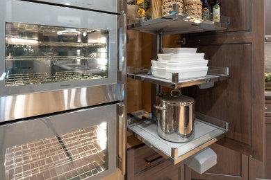 Inspiration for a large contemporary kitchen remodel in Oklahoma City with shaker cabinets, medium tone wood cabinets, quartzite countertops, black backsplash, quartz backsplash, paneled appliances, an island and yellow countertops
