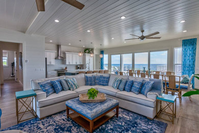 Example of a large beach style open concept medium tone wood floor, shiplap ceiling and shiplap wall living room design in Other with white walls