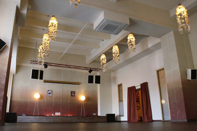 На фото: большая йога-студия в восточном стиле с бежевыми стенами, паркетным полом среднего тона и коричневым полом
