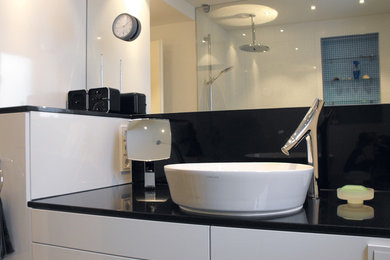 Kleines Modernes Duschbad mit flächenbündigen Schrankfronten, weißen Schränken, bodengleicher Dusche, Wandtoilette, schwarz-weißen Fliesen, Glasfliesen, weißer Wandfarbe, Mosaik-Bodenfliesen, Granit-Waschbecken/Waschtisch und Aufsatzwaschbecken in Stuttgart