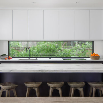Modern Kitchen with Mitered Stone Island, Streamlined Cabinetry & Furnished Seat